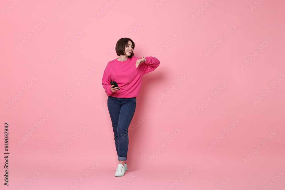 Smiling woman with smartphone on pink background. Space for text Smiling woman with smartphone on pink background. Space for text