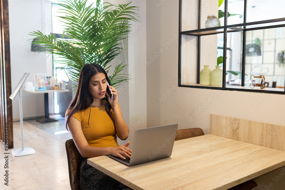 Busy woman talking on smartphone and using laptop Busy woman talking on smartphone and using laptop