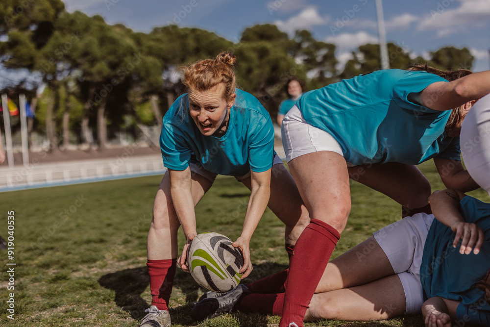 Rugby player holding ball near team on field Rugby player holding ball near team on field