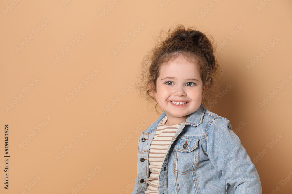 Adorable child. Portrait of happy girl on beige background, space for text Adorable child. Portrait of happy girl on beige background, space for text