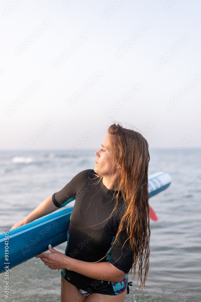 Woman with paddleboard near sea