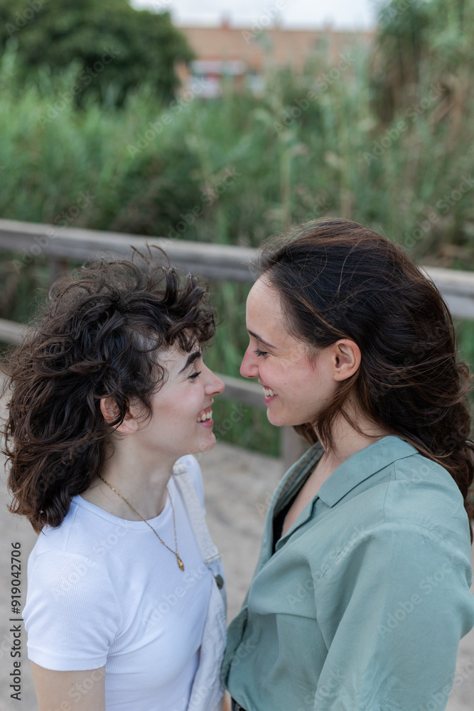 Lesbian couple interacting on bridge in daytime Lesbian couple interacting on bridge in daytime
