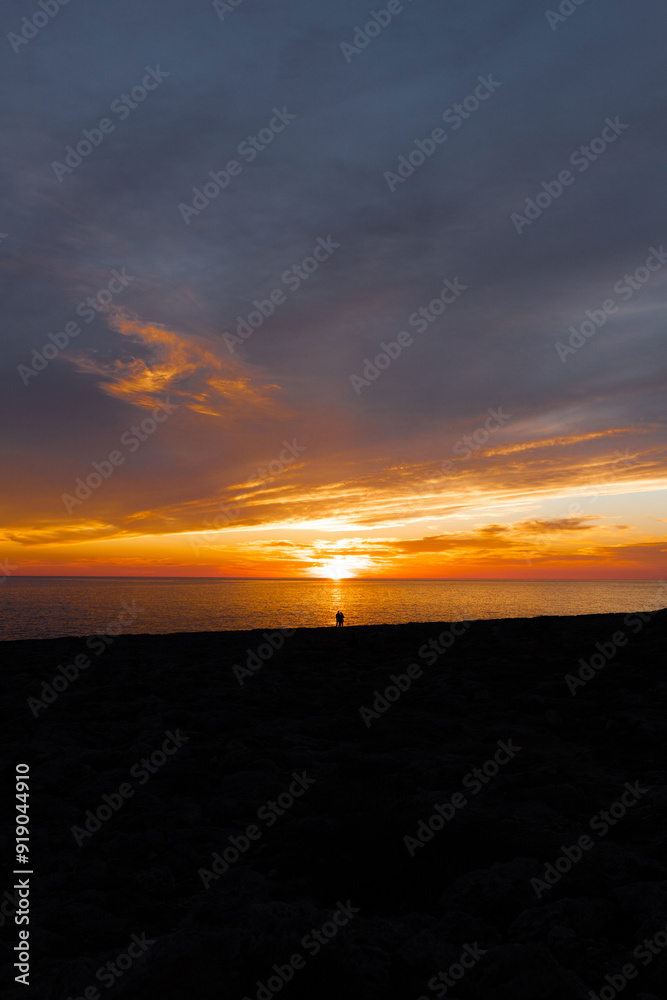 Traveler silhouettes contemplating sea from beach at night Traveler silhouettes contemplating sea from beach at night