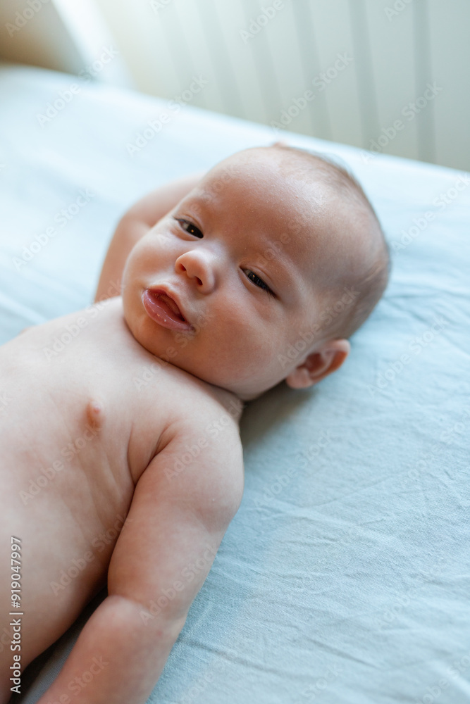 Adorable newborn smiling while lying on bed Adorable newborn smiling while lying on bed