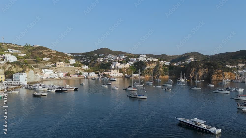 Il porto turistico dell'Isola di Ponza in serena giornata di agosto. Italia, Mediterraneo. 
Vista Aerea dell'ingresso alla marina di Ponza, isola frequentata da mega yacht di tutto il mondo. Mare