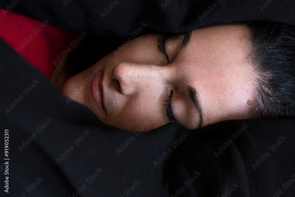 Close-up of a woman sleeping peacefully in dark bedding Close-up of a woman sleeping peacefully in dark bedding