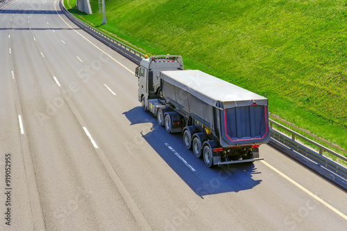 Bilde på lerret Truck huge dump trailer heavy bulk cargo drives fast along the highway aerial ba