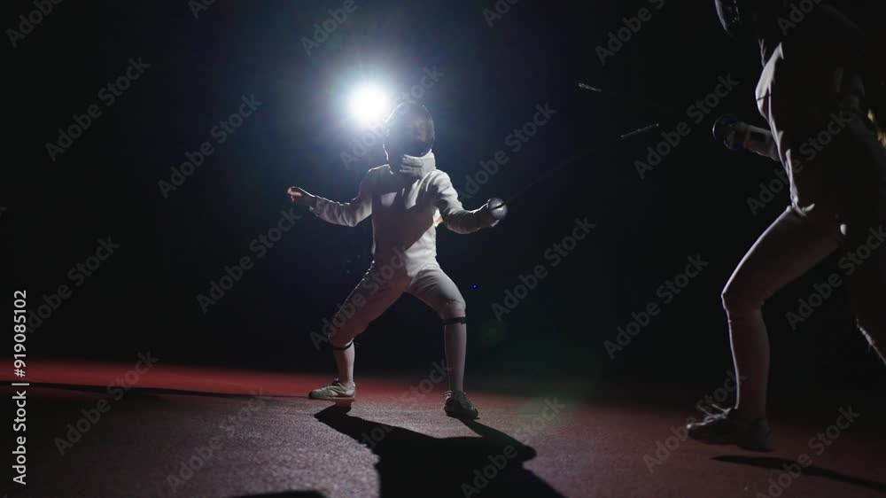 Athletic Women Fighting On Fencing Track, Silhouette Of Graceful Ladies In Uniform In Darkness Athletic Women Fighting On Fencing Track, Silhouette Of Graceful Ladies In Uniform In Darkness