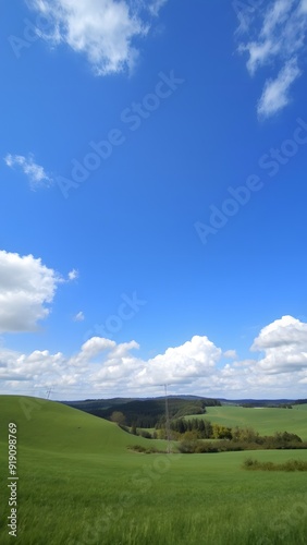 Peaceful Countryside Under Expansive Blue Sky with Serene White Clouds