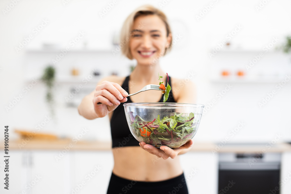 Smiling woman holding glass bowl with fresh salad in modern kitchen. Healthy lifestyle and balanced diet concept. Fitness and nutrition. Smiling woman holding glass bowl with fresh salad in modern kitchen. Healthy lifestyle and balanced diet concept. Fitness and nutrition.