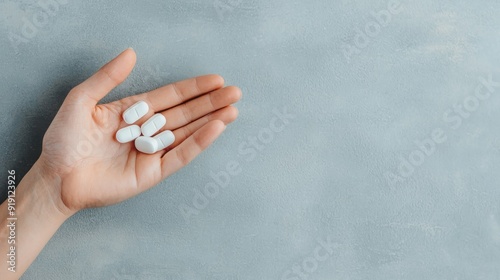 Close-up of a hand holding zinc tablets, energy and immune support, clean background