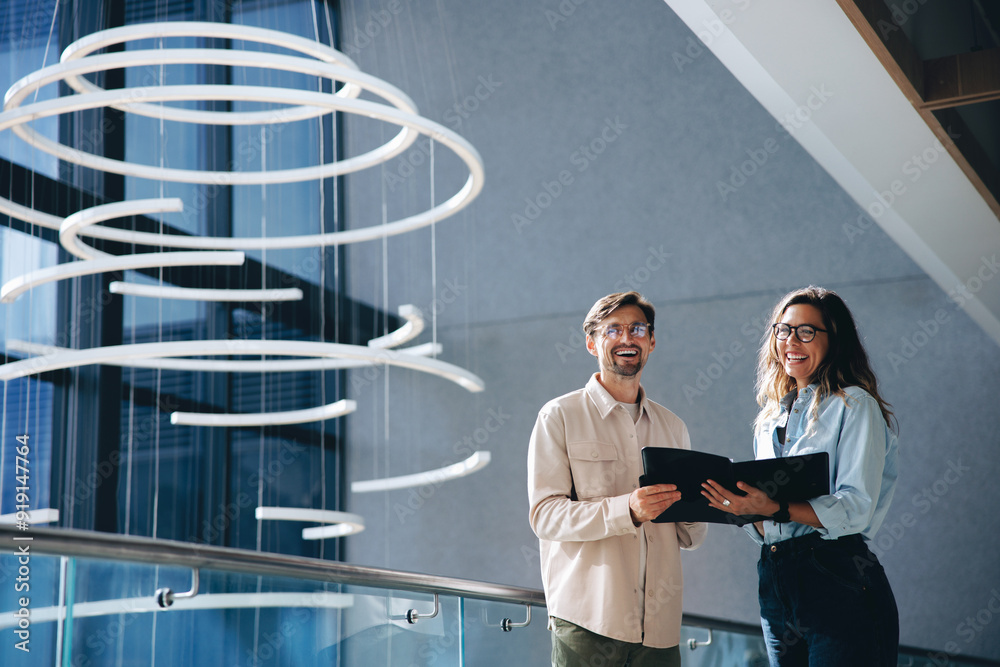 © Jacob Lund - Successful business associates smiling happily as they hold a copy of their deal © Jacob Lund - Successful business associates smiling happily as they hold a copy of their deal