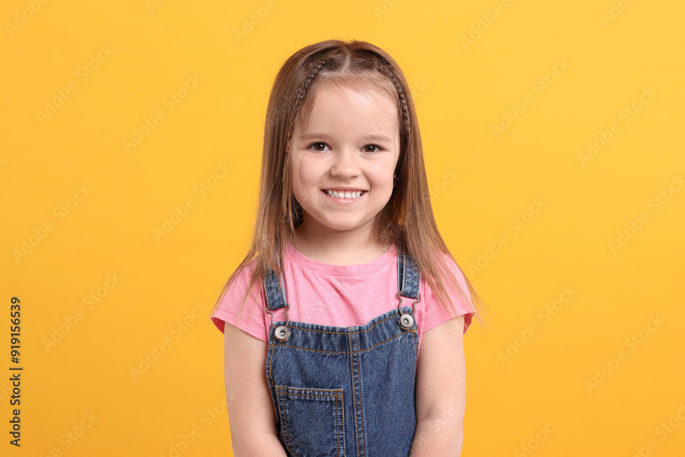 Portrait of happy little girl on orange background Portrait of happy little girl on orange background