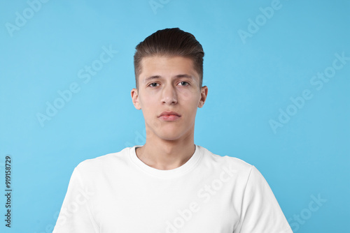 Portrait of handsome young man on light blue background