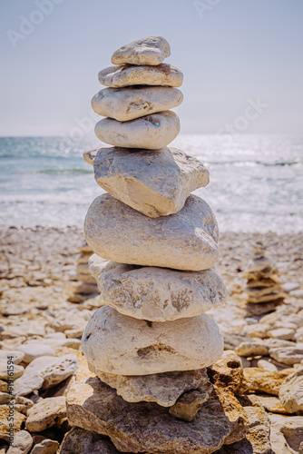 Gros plan d’un cairn en galets blancs sur une plage, face à l’océan Atlantique, île d’Oléron.