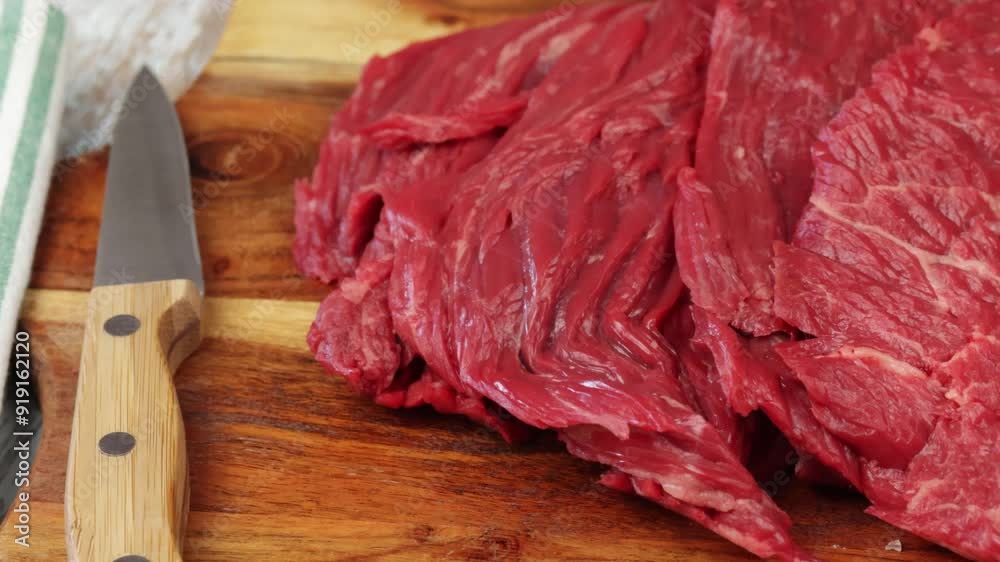 steaks de boeuf cru, en gros plan, sur une planche à découper