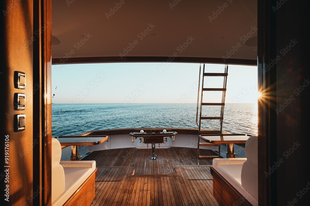 Fototapeta premium Luxurious yacht deck with wooden floor and ocean view at sunset