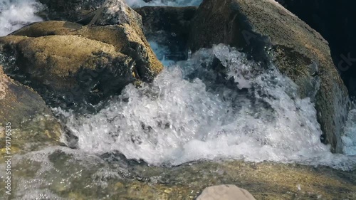 Water cascades over rocks and stones in the river at Weesen, Glarus, Switzerland, highlighting nature's beauty. photo