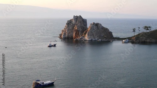 Video of Baikal Lake on summer sunset. Tourists ride a motorboat near the famous Shamanka Rock - Olkhon Island attractions photo