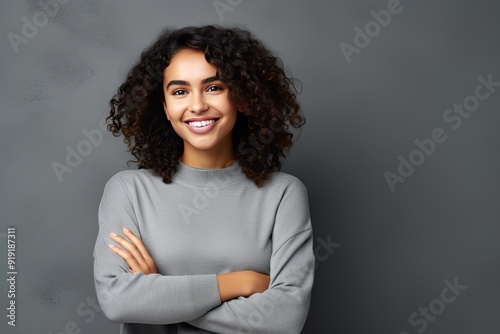 Young latin woman with pleasant smile and crossed arms. photo