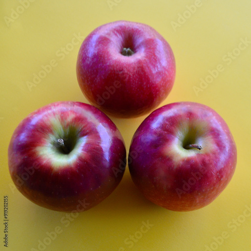 A view of three Pink Lady apples on the table.  photo