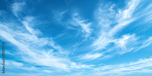 Serene scene of clear blue skies with wispy white clouds drifting peacefully
