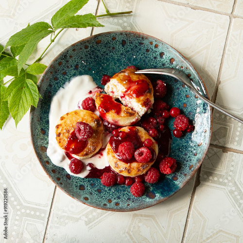 plate with homemade cheesecakes with jam and fresh malia berries on the table