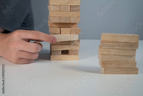 Gra jenga, usuwanie pojedynczych klocków drewnianych z bloku. photo