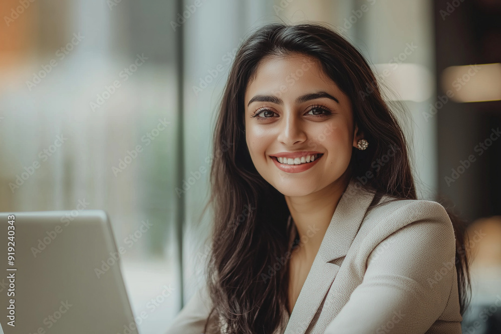 Happy latin hispanic young business woman working on laptop computer in company office. Smiling Indian entrepreneur manager businesswoman using pc for communication, learning at workplace