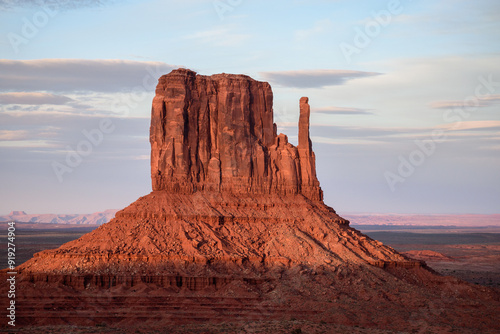 Stunning view of West Mitten Butte in Monument Valley, Arizona, at dusk. The iconic red rock formation glows in the soft evening light, showcasing the natural beauty of the American Southwest - USA photo