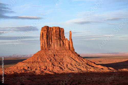 Beautiful view of the iconic West Mitten Butte in Monument Valley, Arizona, illuminated by the warm glow of a stunning sunset. A landscape showcasing the unique geological formations of the Southwest. photo