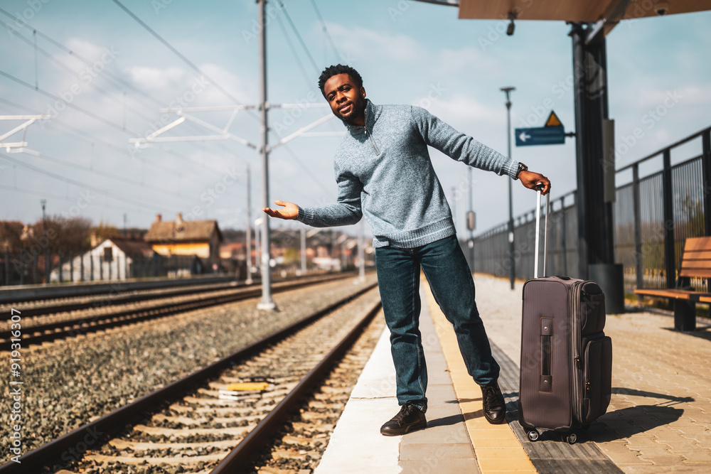 Angry man with a suitcase standing on a railway station. Angry man with a suitcase standing on a railway station.