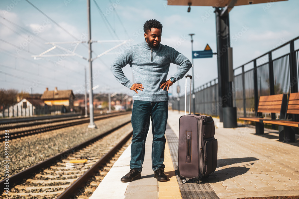Angry man with a suitcase standing on a railway station. Angry man with a suitcase standing on a railway station.