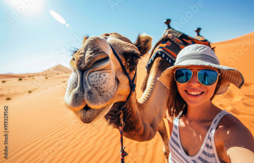 Camel in desert.White American European millenial blon woman wearing headscarf on a hot summers day in the sahara. Morocco camel riding. Selfie with animal. Hump camel ride on vacation holiday egypt.	 photo