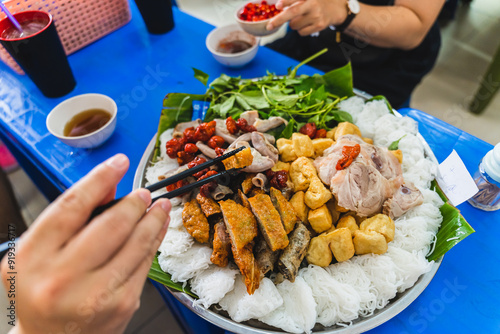 A delicious Vietnamese dish, Bun Dau Mam Tom, is a popular street food made from rice noodles with boiled meat, fried tofu, shrimp paste and green vegetables, cucumber and spices such as chili, lime