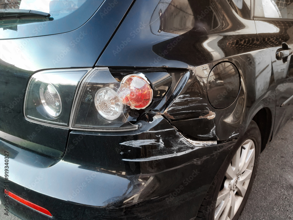 Close-up of a car that suffered a rear-end collision with broken bumper, mudguard and rear light Close-up of a car that suffered a rear-end collision with broken bumper, mudguard and rear light