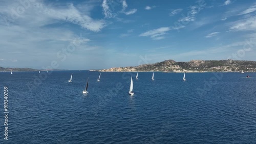 Sailboats enjoy a beautiful day on the water near the coast of Sardinia, Italy. Shot by drone
