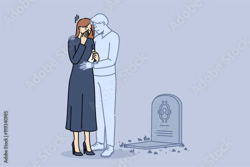 Ghost of husband supports widow crying at grave of deceased groom and suffering from loneliness. Widow girl stands in despair near gravestone in cemetery and needs help from loved ones