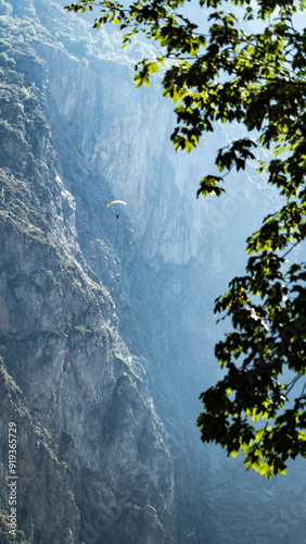 A paraglider against a rocky face of a mountain