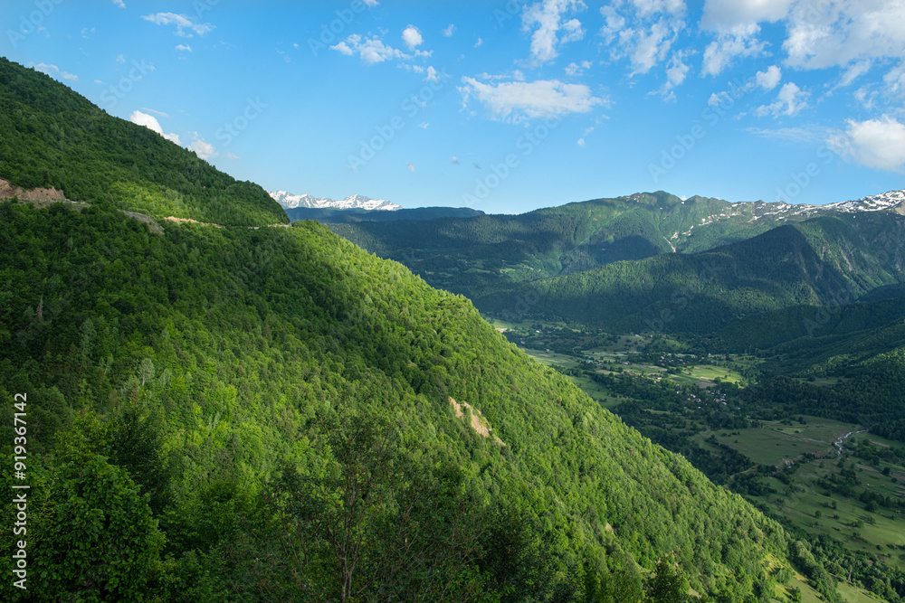 Naklejka premium Georgia trekking routes. Magnificent Georgian mountains. Snowy and green mountains of Georgia. Svaneti mountains. Mountain landscapes in bloom in spring.