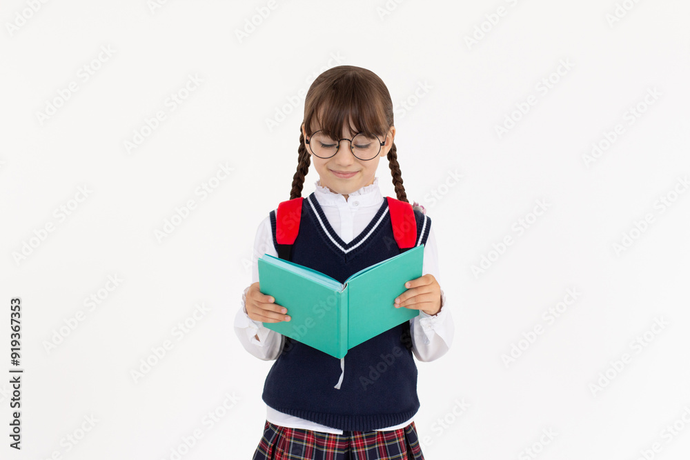 The girl really likes to read an interesting book. Girl in school uniform reading blue book The girl really likes to read an interesting book. Girl in school uniform reading blue book