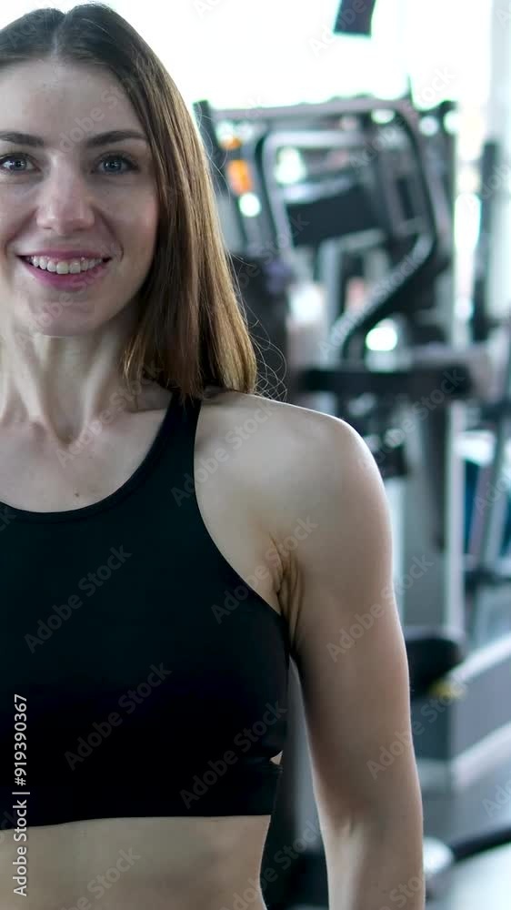 A woman from the back who is engaged in sports equipment in the gym. A slender woman pumps up her back muscles, works with heavy weights. The concept of the structure of the muscles of the body. A woman from the back who is engaged in sports equipment in the gym. A slender woman pumps up her back muscles, works with heavy weights. The concept of the structure of the muscles of the body.