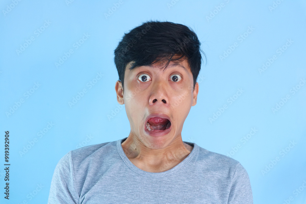 Shocked face of Asian young man in grey t-shirt on a isolated background. Shocked face of Asian young man in grey t-shirt on a isolated background.
