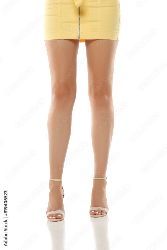 close up of long woman legs in high heeled sandals on a white background close up of long woman legs in high heeled sandals on a white background