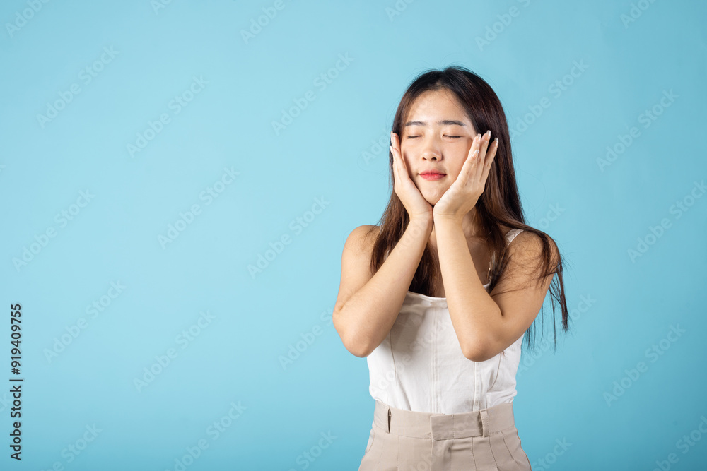 Close up woman smiling with natural makeup and healthy face, Asian young female with beauty face touching healthy facial skin studio shot isolated on blue background, Skin care and Beauty concept Close up woman smiling with natural makeup and healthy face, Asian young female with beauty face touching healthy facial skin studio shot isolated on blue background, Skin care and Beauty concept