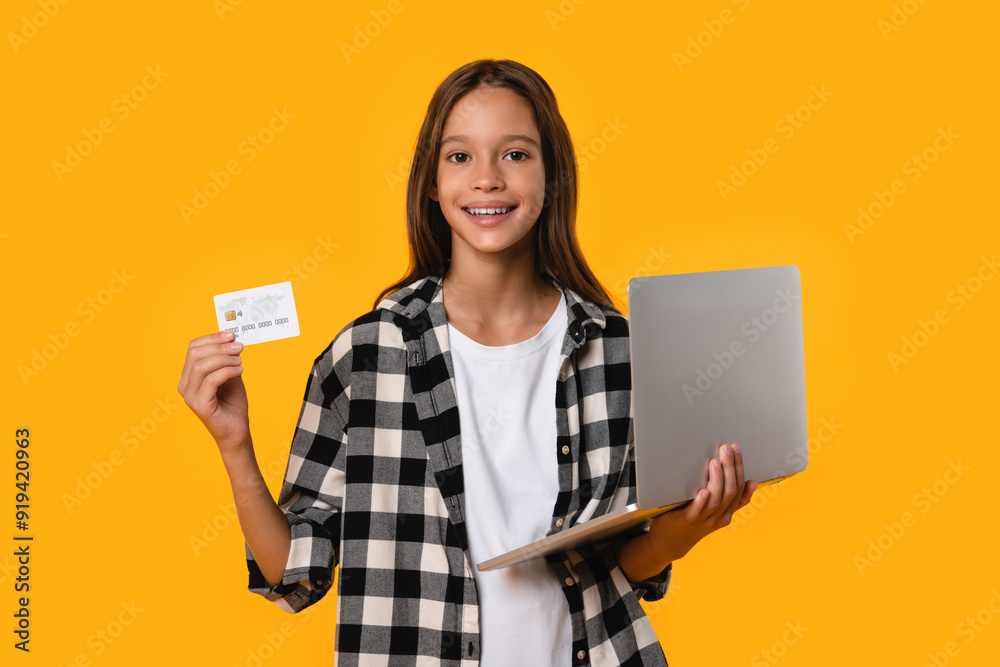 Happy caucasian teenager girl student using laptop for paying with credit card for bills loan debt online, doing shopping, e-banking isolated in yellow background. Happy caucasian teenager girl student using laptop for paying with credit card for bills loan debt online, doing shopping, e-banking isolated in yellow background.