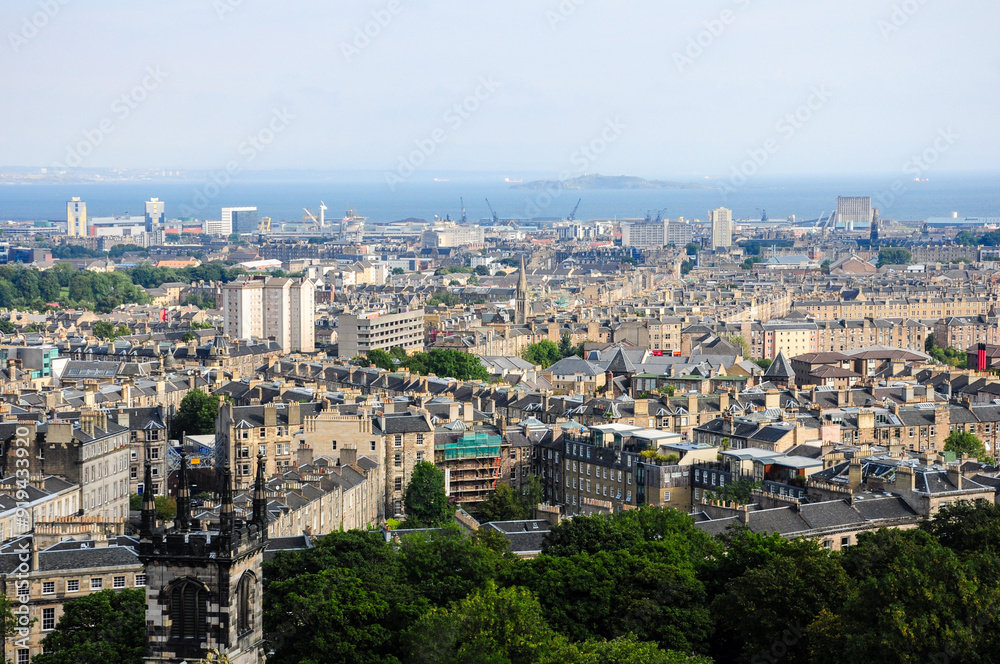 Aerial view of Edinburgh cityscape with historic buildings, greenery, and sea Aerial view of Edinburgh cityscape with historic buildings, greenery, and sea