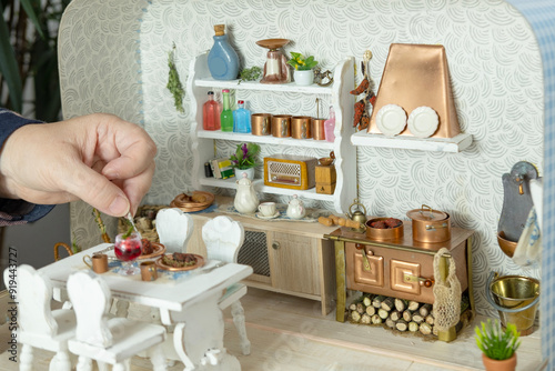 retro-style miniature dollhouse scale kitchen roombox with handcrafted furniture, dishes and utensils, miniature enthusiasts photo