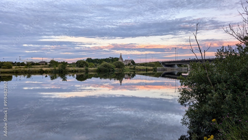 Beautiful sunset scenery, cloudy sky reflected in Corrib river, Terryland castle at Galway, Ireland, nature background