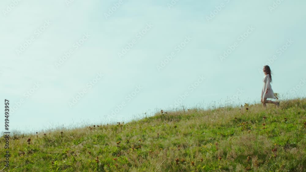 Woman Walking in the mountains with a Bouquet of Wildflowers Woman Walking in the mountains with a Bouquet of Wildflowers